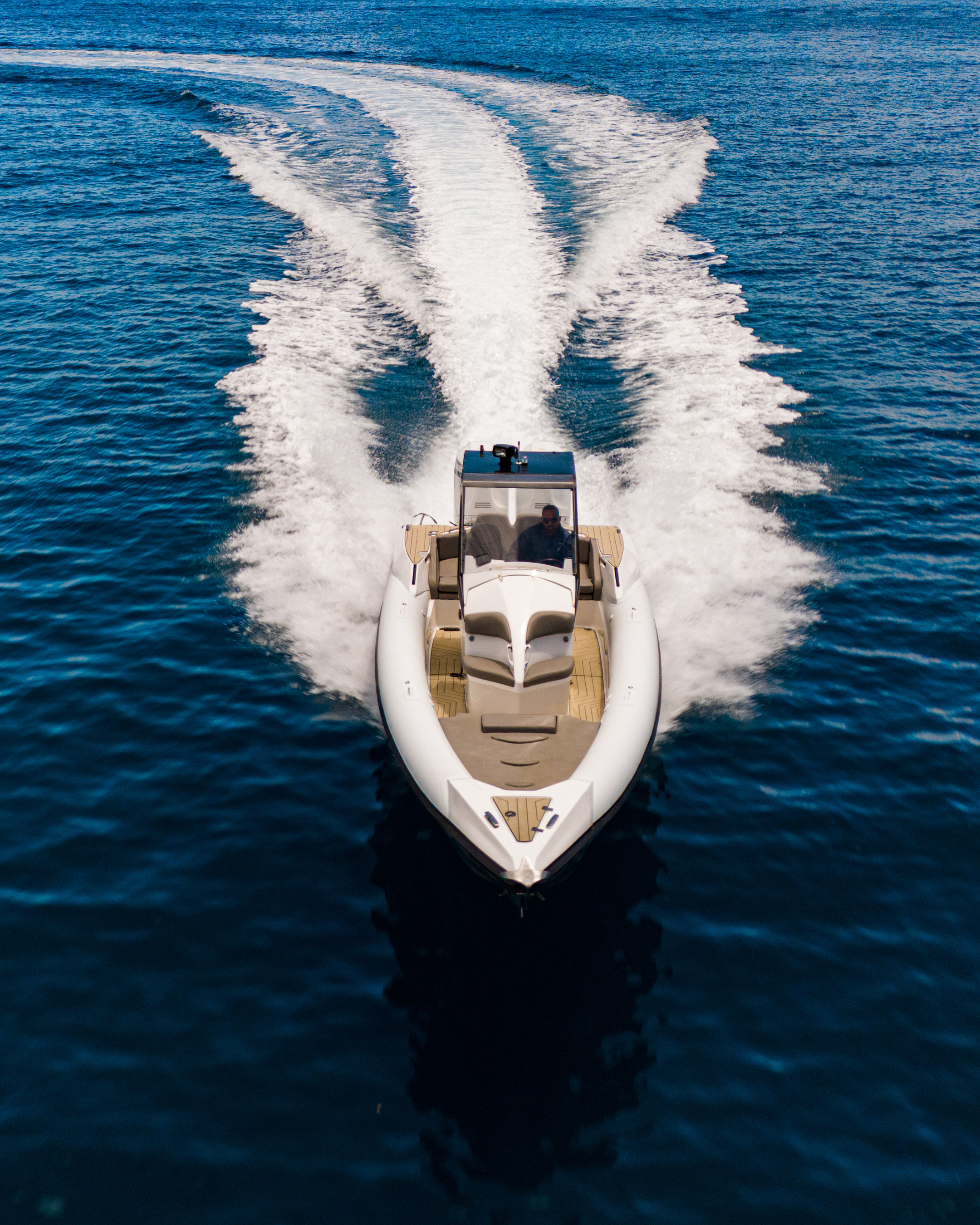 Speedboat leaving a trail of white water on a blue sea